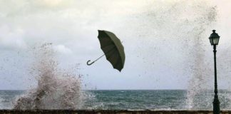 ομπρέλα που την παίρνει ο αέρας κοντά στη θάλασσα