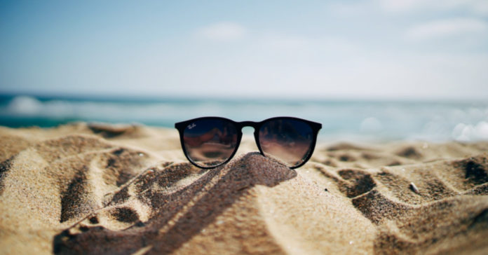 Γυαλιά ηλίου πάνω σε αμμώδη παραλία