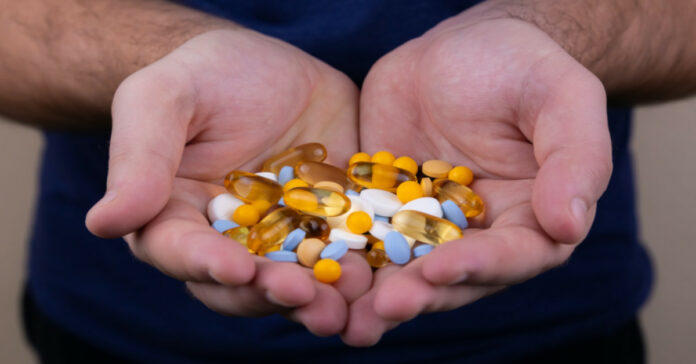 άνδρας κρατάει φάρμακα και αντιβιοτικά