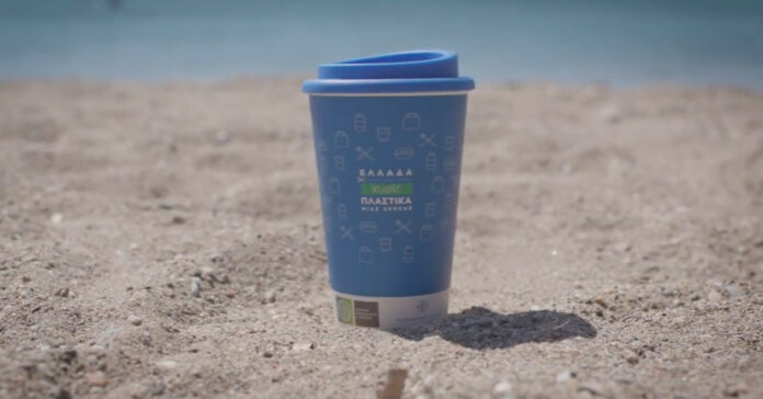 Επαναχρησιμοποιούμενο μπλε ποτήρι με καπάκι στην παραλία