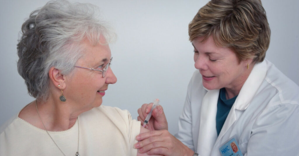 Γυναίκα γιατρός εμβολιάζει γυναίκα άνω των 60