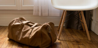 Βαλίτσα μπροστά από καρέκλα σε ξύλινο πάτωμα