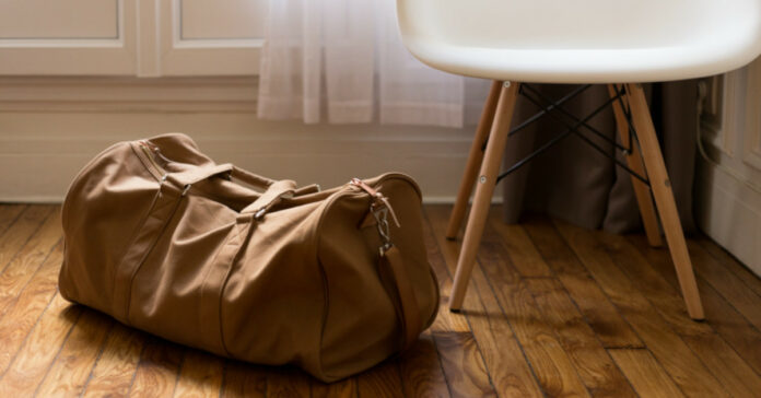 Βαλίτσα μπροστά από καρέκλα σε ξύλινο πάτωμα