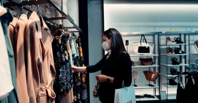 Γυναίκα με μάσκα σε κατάστημα ρούχων